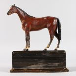 A GOOD 1930'S PAINTED METAL FIGURE OF A STANDING HORSE on a wooden plinth. 5ins high.