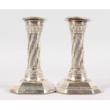 A PAIR OF VICTORIAN CANDLESTICKS with beaded edge on octagonal bases. 5ins high. London 1893. Maker: