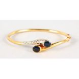 AN 18CT YELLOW GOLD SAPPHIRE SET BANGLE.