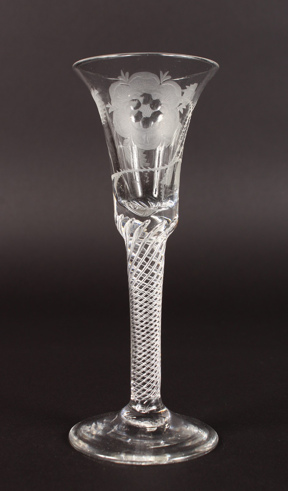 A JACOBITE WINE GLASS, the bowl engraved with six petal rose, with air twist stem. 6ins high.