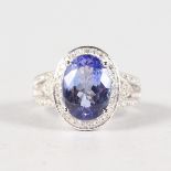 A 14K WHITE GOLD AND DIAMOND RING SET WITH AN OVAL CUT TANZANITE, approx. 3.88ct, diamonds approx.