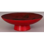 A SIGNED JAPANESE MEIJI PERIOD RED LACQUER BOWL, raised on a splayed foot, the interior decorated