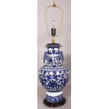 A CHINESE BLUE & WHITE PORCELAIN VASE, fitted for electricity with a fitted wood stand, 29.5in