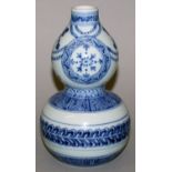 A CHINESE MING STYLE BLUE & WHITE DOUBLE GOURD PORCELAIN VASE, decorated with formal borders and