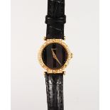 A LADIES' YELLOW GOLD PIAGET WRISTWATCH with diamond bezel on a leather strap.