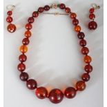 AN AMBER-STYLE NECKLACE & MATCHING EARRINGS, each piece composed of graduated spherical beads, the