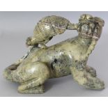 A 20TH CENTURY CHINESE GREEN HARDSTONE CARVING, modelled in the form of a hound biting the tail of a