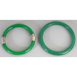 TWO APPLE GREEN JADE LIKE BANGLES, the largest 3.25in diameter. (2)