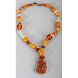 A CHINESE NECKLACE WITH A JADE LIKE PENDANT, the necklace with glass beads and some amber-like