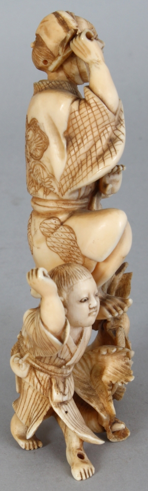 A JAPANESE MEIJI PERIOD IVORY OKIMONO OF A FARMER & HIS SON, unsigned, leaping before two giant - Image 2 of 8