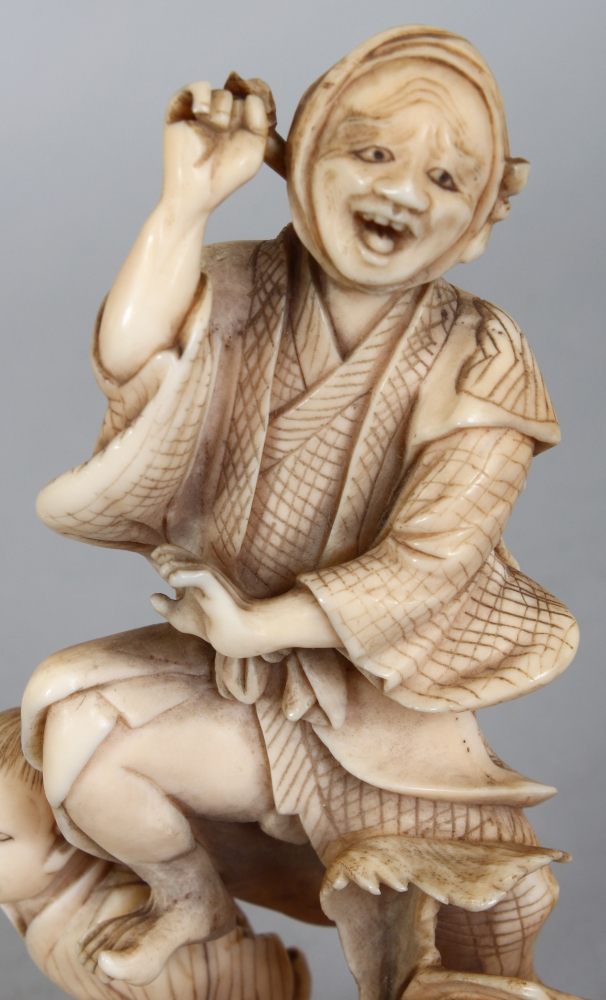 A JAPANESE MEIJI PERIOD IVORY OKIMONO OF A FARMER & HIS SON, unsigned, leaping before two giant - Image 5 of 8
