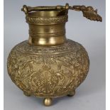 AN INDIAN BRONZE ALLOY HANGING JAR, with a separate ladle, the sides cast in relief with repeated
