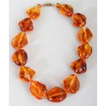 AN AMBER-STYLE NECKLACE, composed of irregular beads, together with an 'authenticity' certificate,