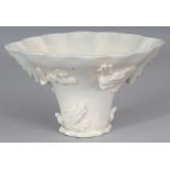 A GOOD CHINESE KANGXI PERIOD DEHUA BLANC-DE-CHINE LIBATION CUP, of rhinoceros horn form, the sides