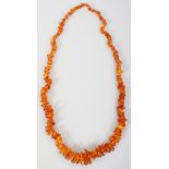 AN AMBER NECKLACE, weighing approx. 75gm, composed of irregularly formed beads, approx. 45in long.