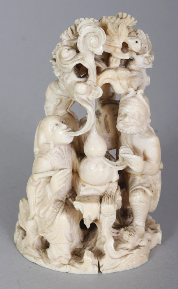 A JAPANESE MEIJI PERIOD IVORY OKIMONO OF A GROUP OF THREE IMMORTALS & A BOY ATTENDANT IN A PINE