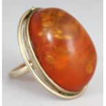 AN AMBER & SILVER-METAL RING, 1.3in long.