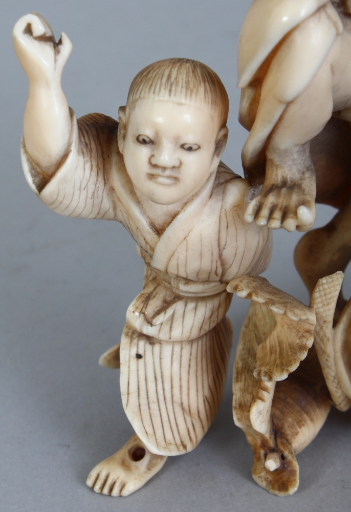 A JAPANESE MEIJI PERIOD IVORY OKIMONO OF A FARMER & HIS SON, unsigned, leaping before two giant - Image 6 of 8