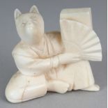 AN EARLY 20TH CENTURY JAPANESE IVORY NETSUKE OF A SEATED FOX, unsigned, the fox holding a fan, 1.
