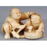 A JAPANESE MEIJI PERIOD IVORY OKIMONO OF A SEATED ARTISAN & HIS SON, unsigned, 2.1in wide & 1.3in