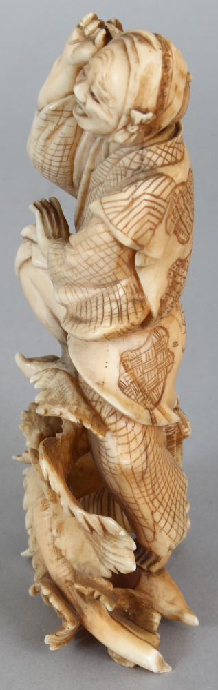 A JAPANESE MEIJI PERIOD IVORY OKIMONO OF A FARMER & HIS SON, unsigned, leaping before two giant - Image 4 of 8