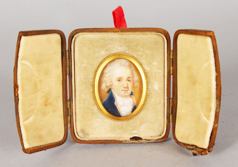 A SMALL 18TH CENTURY OVAL PORTRAIT MINIATURE OF A GENTLEMAN, wearing a blue coat and white cravat.