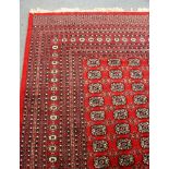 A LARGE RED GROUND BOKHARA CARPET