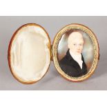 AN EARLY 19TH CENTURY OVAL PORTRAIT MINIATURE OF A YOUNG MAN with blonde hair, black coat and