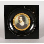 A 19TH CENTURY CIRCULAR PORTRAIT MINIATURE OF A YOUNG LADY wearing a lace bonnet and dark dress. 8.