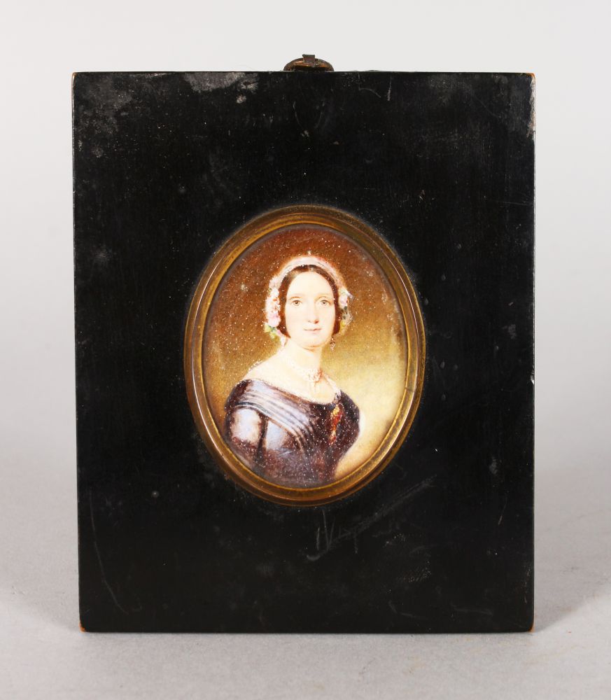 A VICTORIAN OVAL PORTRAIT MINIATURE OF A LADY in a blue dress with lace bonnet. 5.5cms x 4.5cms with