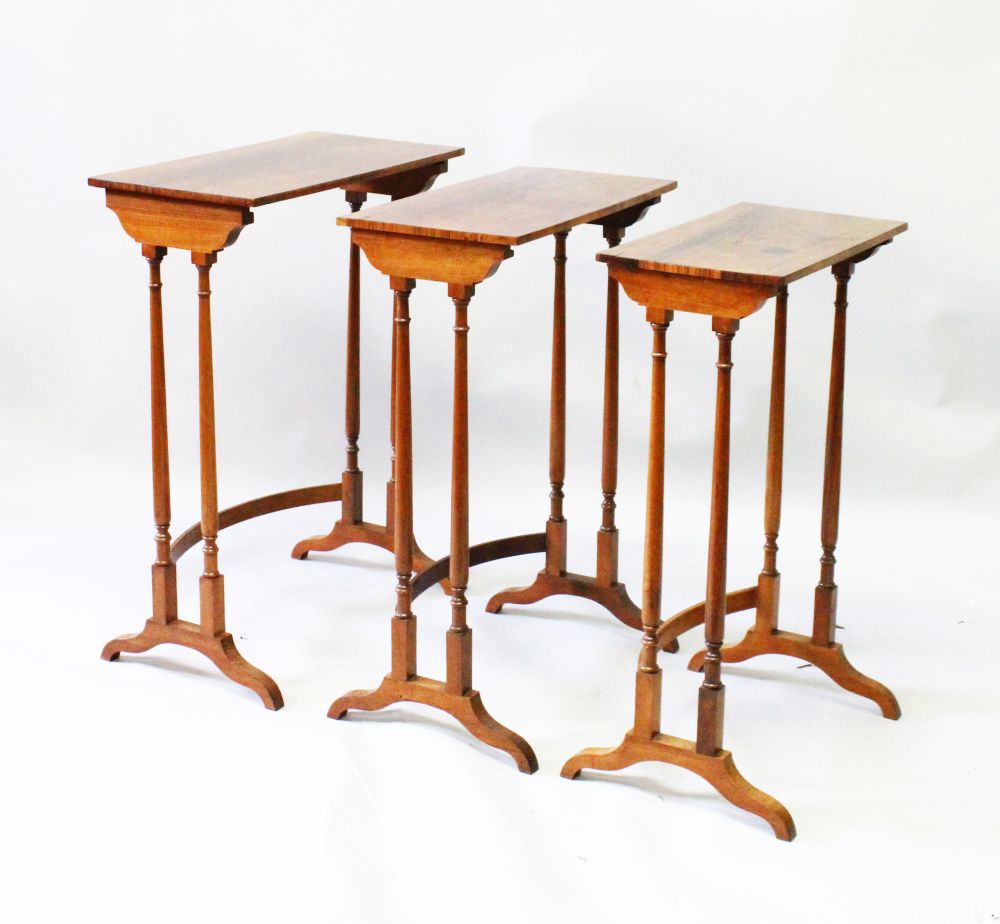A GOOD NEST OF THREE REGENCY MAHOGANY TABLES with plain rectangular tops and turned supports.