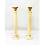 A PAIR OF BEIGE MARBLE PEDESTALS, the octagonal tops with Corinthian style gilt metal supports,
