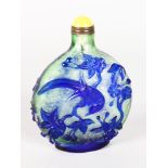 A BLUE PEKING GLASS SNUFF BOTTLE, decorated with birds in relief, with yellow stopper. 4ins high.