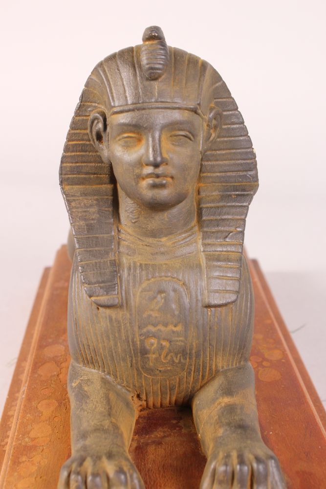 AN EGYPTIAN SPHINX on a mahogany base. 13ins long. - Image 4 of 4