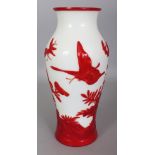 A CHINESE RED OVERLAY GLASS VASE, decorated in relief with butterflies in flight above flowers and