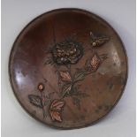 A SMALL JAPANESE MEIJI PERIOD MIXED METAL CIRCULAR DISH, decorated in relief with a bird in flight