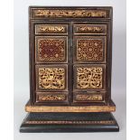 A 19TH/20TH CENTURY CHINESE GILT WOOD CABINET, the two hinged front doors with a variety of raised