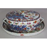 AN 18TH CENTURY CHINESE CLOBBERED OVAL PORCELAIN TUREEN, COVER & STAND, each fluted piece with river