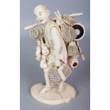 A FINE QUALITY SIGNED JAPANESE SECTIONAL IVORY OKIMONO OF A DRUM SELLER, carrying drums, an Okame