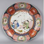A 19TH CENTURY JAPANESE IMARI PORCELAIN CHARGER, painted to its centre with an unusual scene of