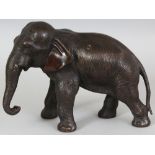 A SIGNED JAPANESE MEIJI PERIOD BRONZE MODEL OF AN ELEPHANT BY SEIYA, the elephant striding forwards,