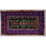 AN EASTERN EMBROIDERED FABRIC & PATTERNED SILK SPREAD, 64.5in x 38in.