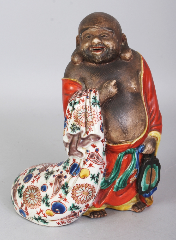 A JAPANESE MEIJI PERIOD KUTANI PORCELAIN FIGURE OF HOTEI, standing with a cheerful expression and