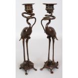 A PAIR OF JAPANESE MEIJI PERIOD BRONZE CANDLESTICKS, each cast in the form of a crane standing on