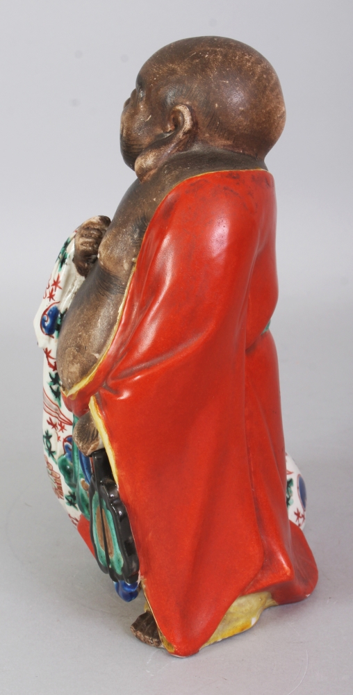 A JAPANESE MEIJI PERIOD KUTANI PORCELAIN FIGURE OF HOTEI, standing with a cheerful expression and - Image 4 of 7