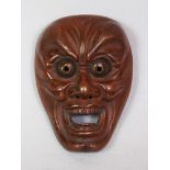 A JAPANESE MEIJI PERIOD BRONZE MODEL OF A NOH MASK, depicting a demonic character, 2.3in high.