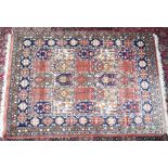 AN UNUSUAL PERSIAN RUG with twenty-five squares within a triple border. 5ft 8ins x 4ft 2ins.