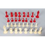 A RED AND WHITE TURNED IVORY CHESS SET.