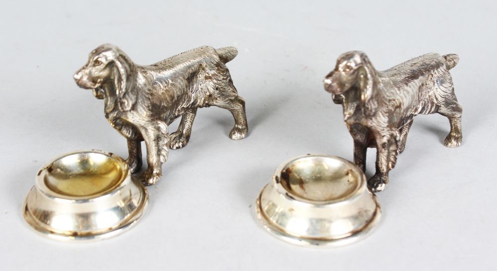 A PAIR OF SILVER RETRIEVERS with feeding bowl. 4ins long.