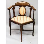 AN EDWARDIAN MAHOGANY INLAID CORNER CHAIR with padded back and seat.